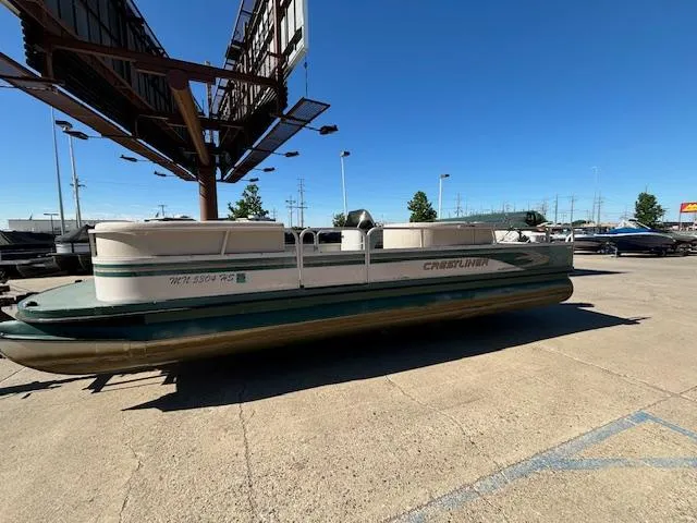 Slide: The Image of 1999 Crestliner 2480 SPORT LX pontoon boat parked outdoors on a sunny day. - 1