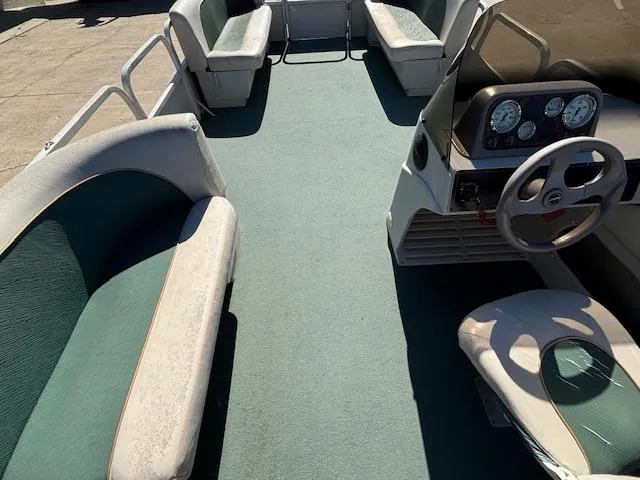 Slide: The Image of 1999 Crestliner 2480 SPORT LX boat interior with green carpet and seating. - 12