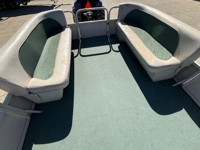 Slide: The Image of 1999 Crestliner 2480 SPORT LX boat interior with green carpet and cushioned seating. - 14