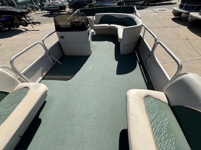 Slide: The Image of 1999 Crestliner 2480 SPORT LX pontoon boat with spacious seating and green carpet. - 16