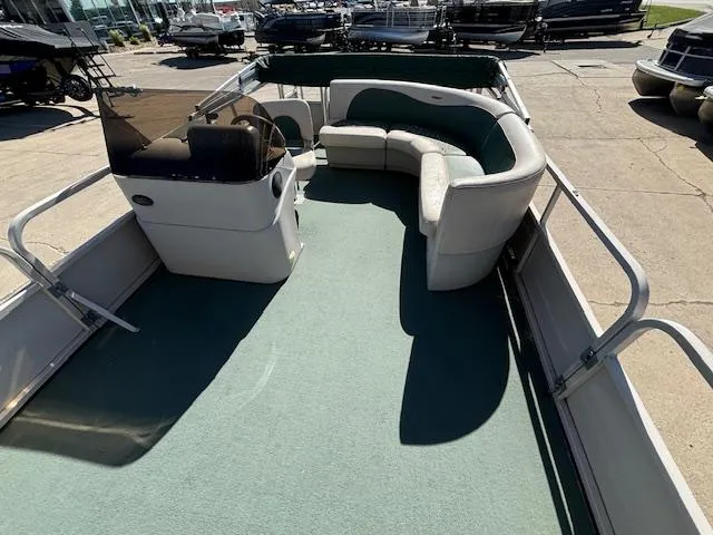 Slide: The Image of 1999 Crestliner 2480 SPORT LX pontoon boat with spacious seating and helm, docked outdoors. - 17