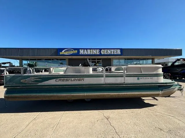 Slide: The Image of 1999 Crestliner 2480 SPORT LX pontoon boat at a marine center. - 6