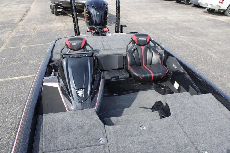 Slide: The Image of 2026 Skeeter ZXE21 boat interior with black and red seats, parked on pavement. - 13