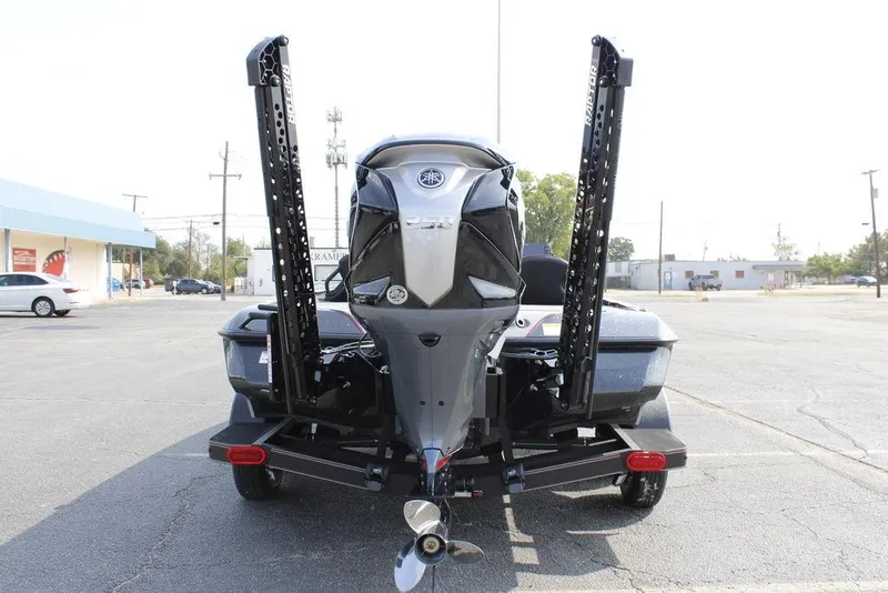 Slide: The Image of 2026 Skeeter ZXE21 boat rear view with motor and power poles in parking lot. - 4