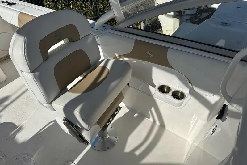 Slide: The Image of 2014 Edgewater 245CX Crossover boat interior with white and tan seating and cup holders. - 10