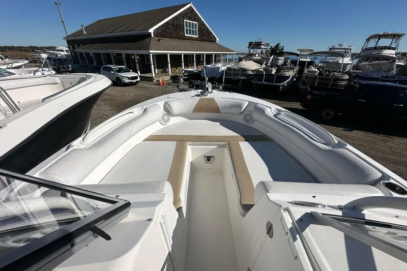 Slide: The Image of 2014 Edgewater 245CX Crossover boat with spacious seating, docked near a marina. - 11