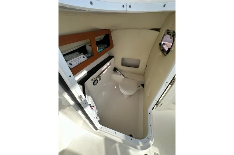 Slide: The Image of 2014 Edgewater 245CX Crossover boat interior with compact marine toilet and storage. - 13