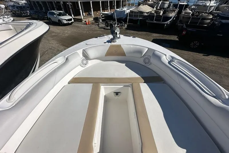 Slide: The Image of 2014 Edgewater 245CX Crossover boat interior with seating and storage, docked at marina. - 16