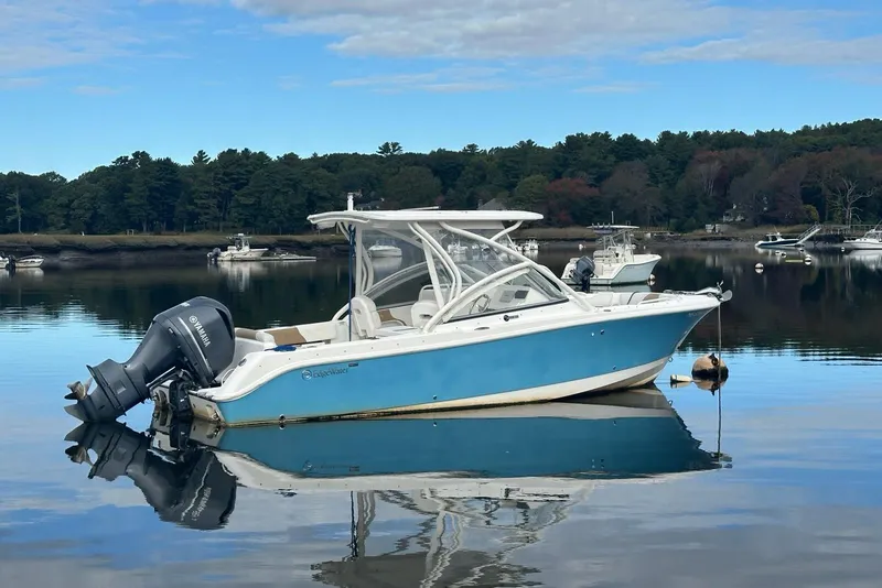 Slide: The Image of 2014 Edgewater 245CX Crossover boat on calm water with scenic background. - 2