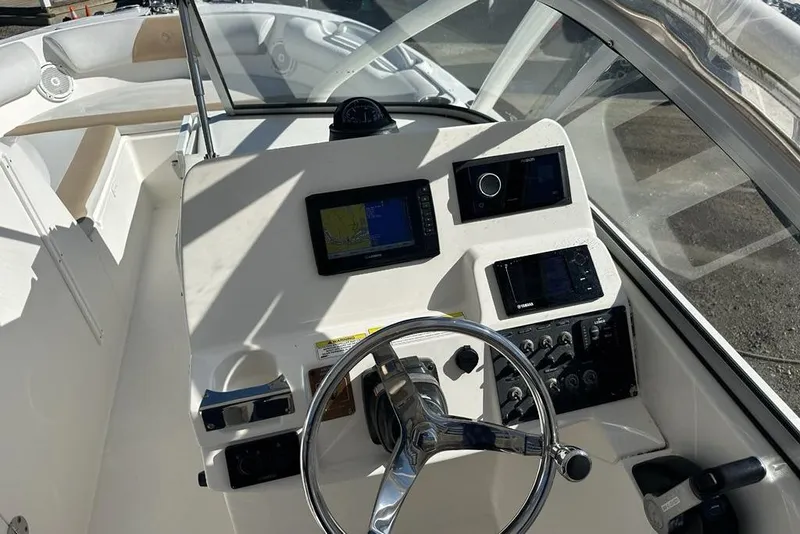 Slide: The Image of 2014 Edgewater 245CX Crossover boat dashboard with steering wheel and navigation instruments. - 4
