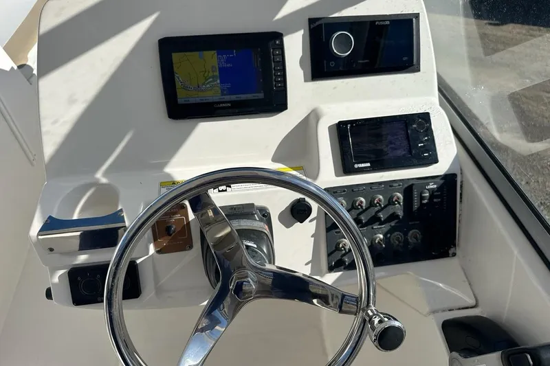 Slide: The Image of 2014 Edgewater 245CX Crossover boat dashboard with steering wheel and navigation controls. - 5