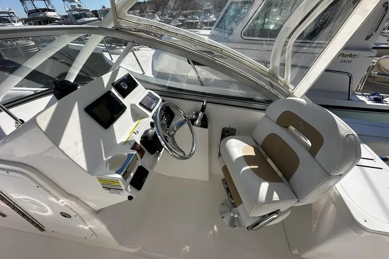 Slide: The Image of 2014 Edgewater 245CX Crossover boat interior with steering wheel and captain's chair. - 7
