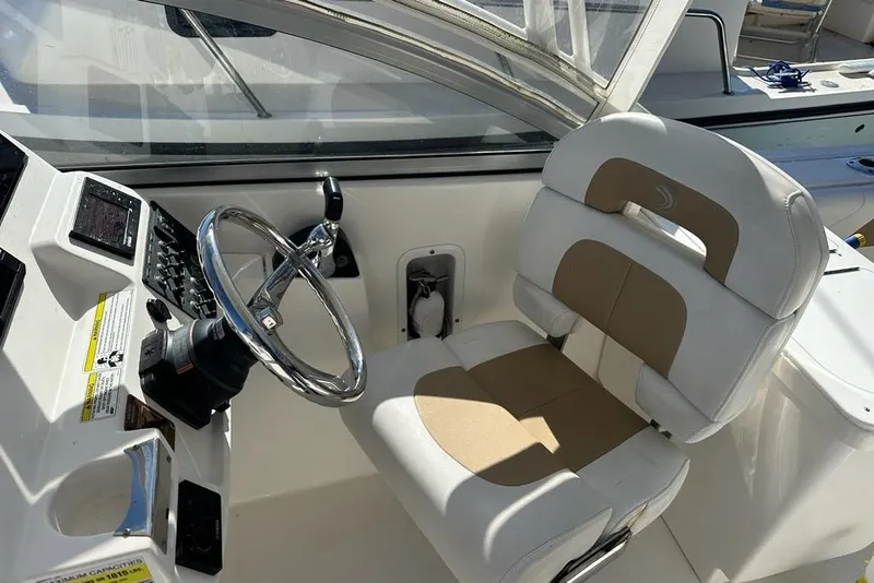 Slide: The Image of 2014 Edgewater 245CX Crossover boat cockpit with steering wheel and captain's chair. - 8