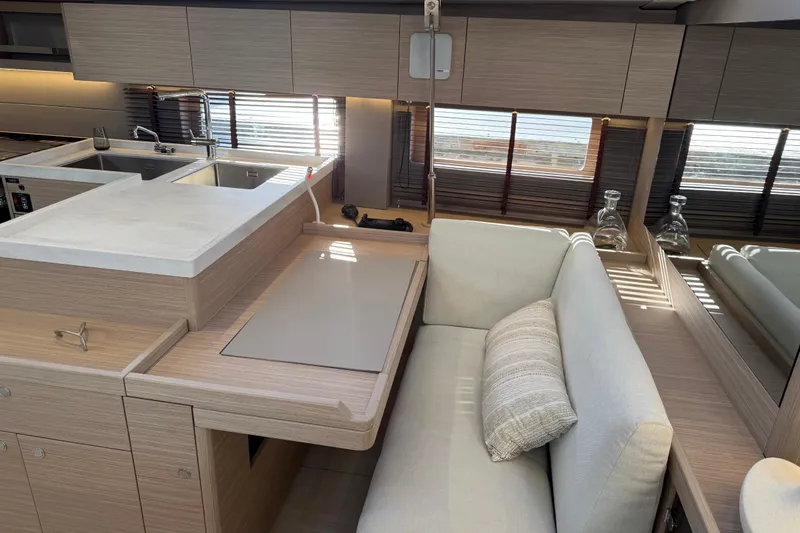 Slide: The Image of Interior of 2026 Beneteau Oceanis 52 yacht, featuring modern kitchen and cozy seating area. - 12