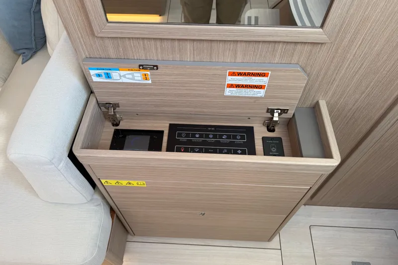 Slide: The Image of Control panel inside Beneteau Oceanis 52 yacht, 2026 model, with warning labels and switches. - 13