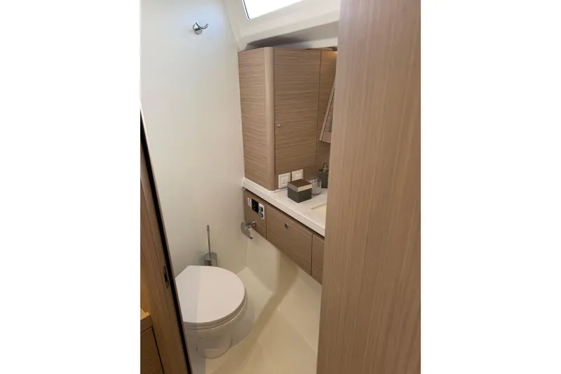 Slide: The Image of Modern bathroom interior of 2026 Beneteau Oceanis 52 yacht, featuring sleek wood cabinetry. - 17