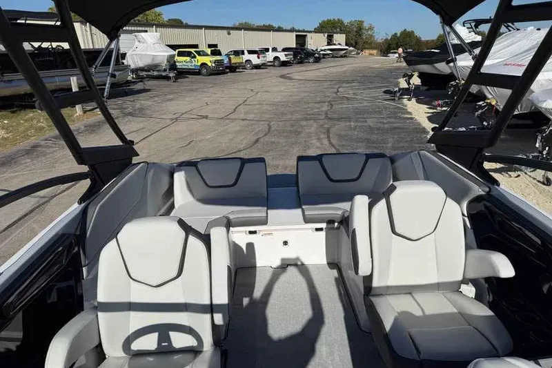 Slide: The Image of 2026 Yamaha Boats AR250 interior with modern seating, parked in a boatyard. - 12