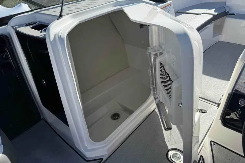 Slide: The Image of 2026 Yamaha Boats AR250 interior storage compartment with open door, showcasing spacious design. - 14