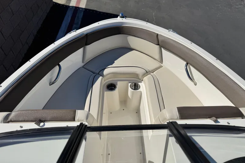 Slide: The Image of 2019 Bayliner 180 Bowrider boat interior with cushioned seating and cup holders. - 11
