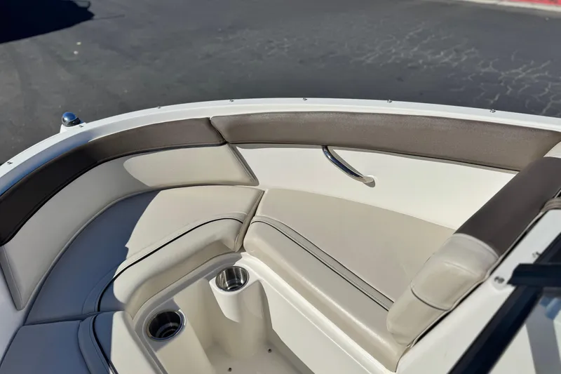 Slide: The Image of 2019 Bayliner 180 Bowrider boat interior with cushioned seating and cup holders. - 13