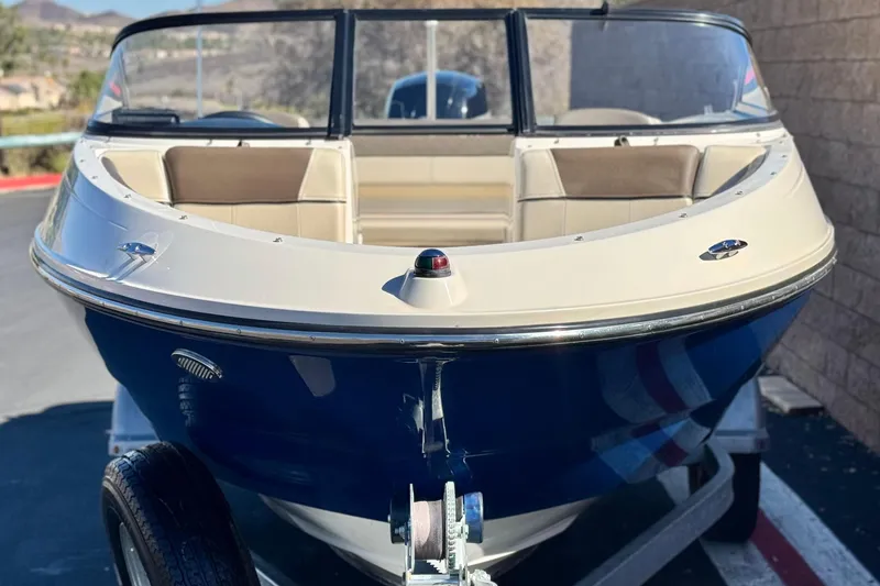 Slide: The Image of 2019 Bayliner 180 Bowrider boat on trailer, front view, outdoors. - 2