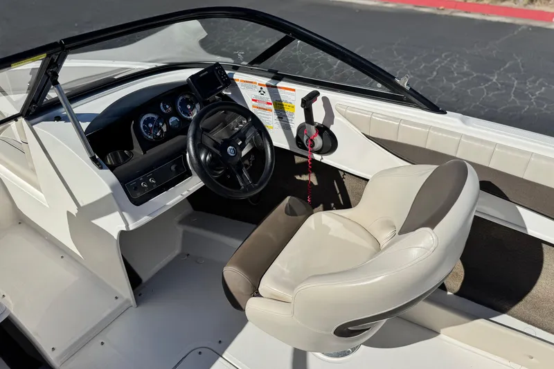 Slide: The Image of 2019 Bayliner 180 Bowrider interior with steering wheel, dashboard, and comfortable seating. - 20