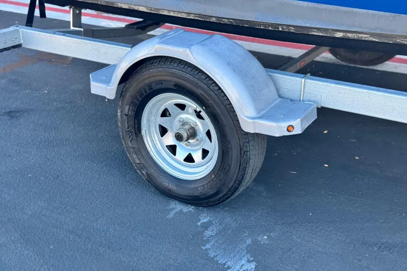 Slide: The Image of Trailer wheel of a 2019 Bayliner 180 Bowrider on asphalt surface. - 23