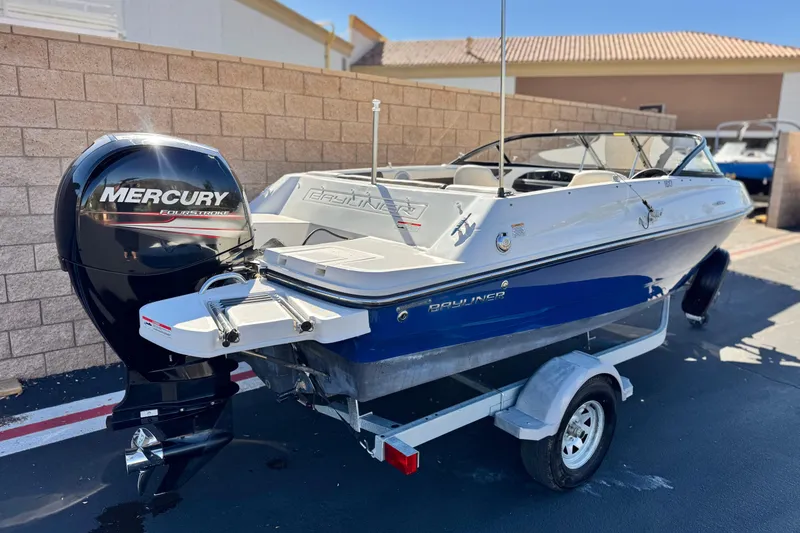 Slide: The Image of 2019 Bayliner 180 Bowrider with Mercury engine on trailer, parked outdoors. - 5