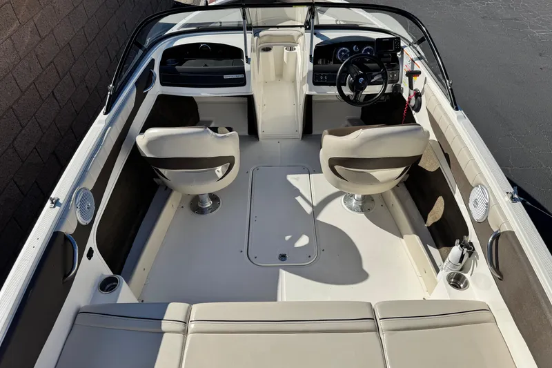 Slide: The Image of 2019 Bayliner 180 Bowrider interior with seating and steering wheel, viewed from above. - 8