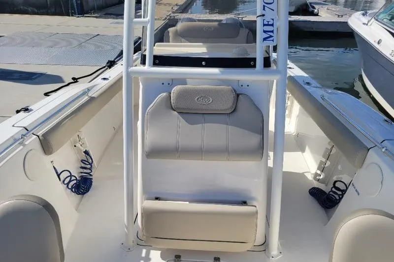 Slide: The Image of 2023 Key West 244 Center Console boat interior with seating and storage at a marina. - 12