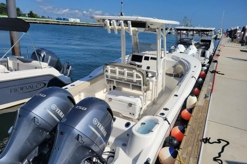 Slide: The Image of 2023 Key West 244 Center Console boat docked with twin Yamaha engines. - 2