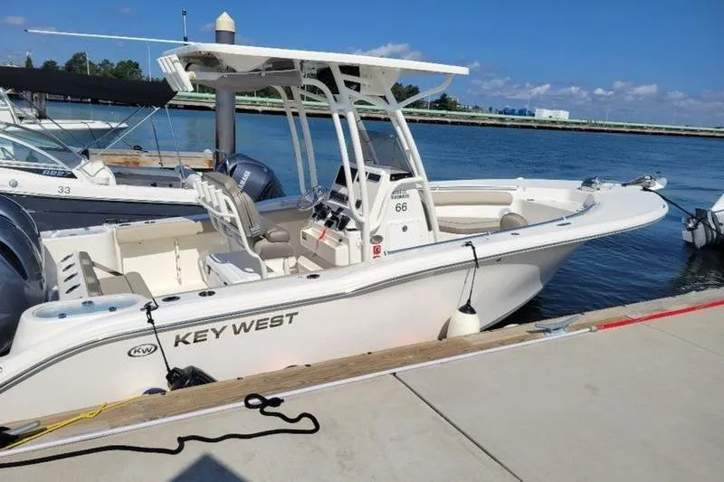 Slide: The Image of 2023 Key West 244 Center Console boat docked at marina under clear blue sky. - 4