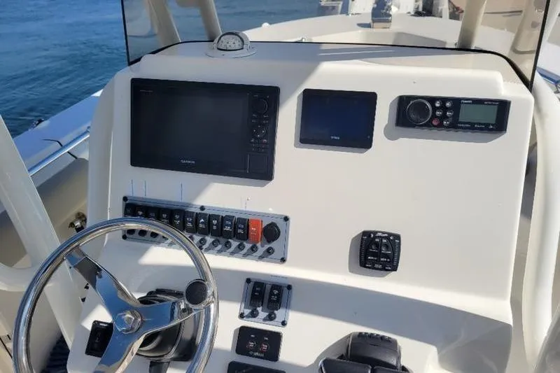 Slide: The Image of 2023 Key West 244 Center Console boat dashboard with steering wheel and navigation controls. - 5