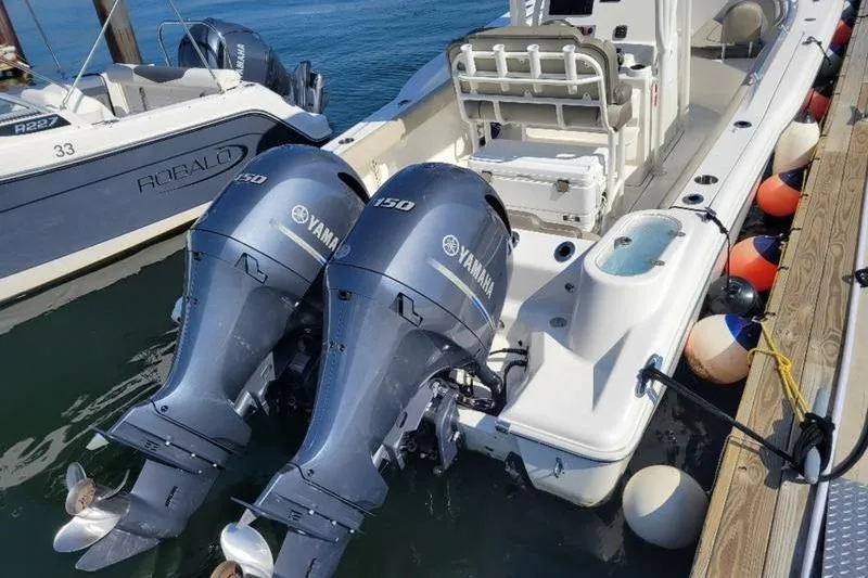 Slide: The Image of 2023 Key West 244 Center Console boat with dual Yamaha 150 engines docked. - 6
