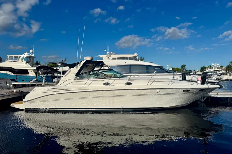 The Image of 1998 Sea Ray 400 Sundancer yacht docked under a clear blue sky. - 0