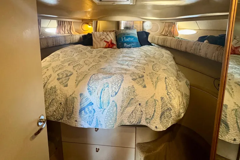 Slide: The Image of Cozy cabin interior of 1998 Sea Ray 400 Sundancer with nautical-themed bedding. - 11
