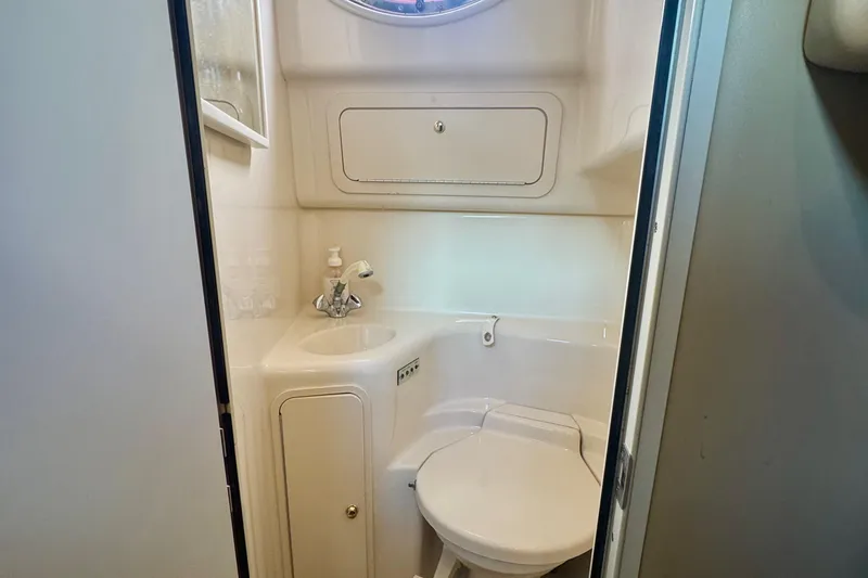 Slide: The Image of 1998 Sea Ray 400 Sundancer bathroom with sink, toilet, and storage cabinet. - 14
