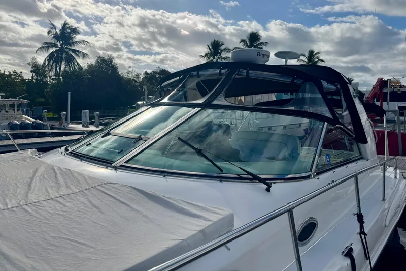 Slide: The Image of 1998 Sea Ray 400 Sundancer yacht docked under a partly cloudy sky. - 3