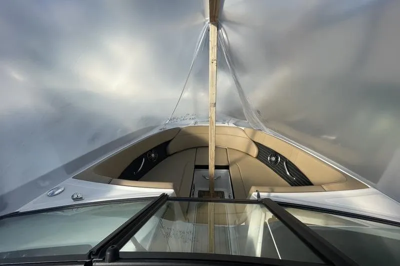Slide: The Image of 2024 Sea Ray 230 Sportster Bow Rider under protective cover, showcasing interior seating. - 10