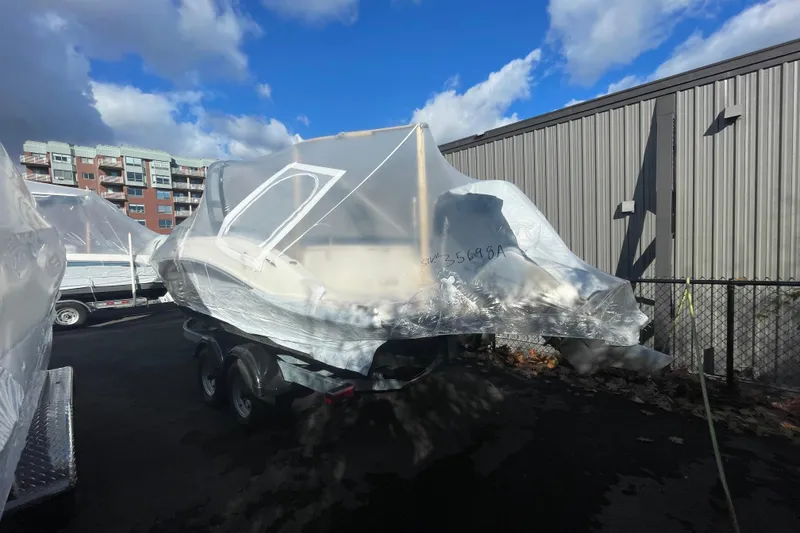 Slide: The Image of 2024 Sea Ray 230 Sportster Bow Rider wrapped in protective covering, parked outdoors. - 13