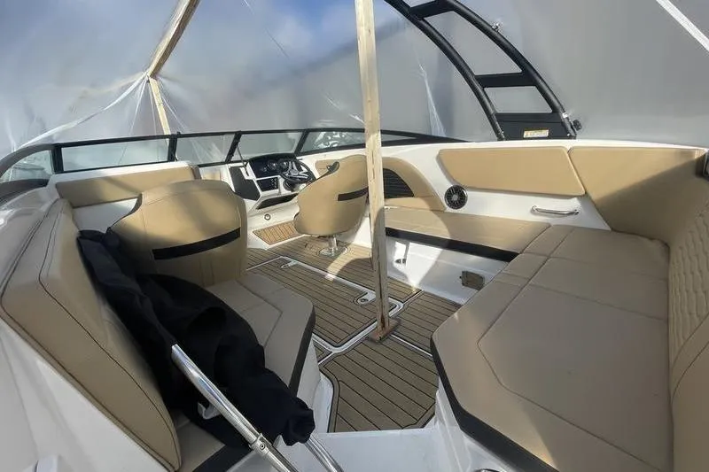 Slide: The Image of 2024 Sea Ray 230 Sportster Bow Rider interior with tan seating and modern dashboard. - 4