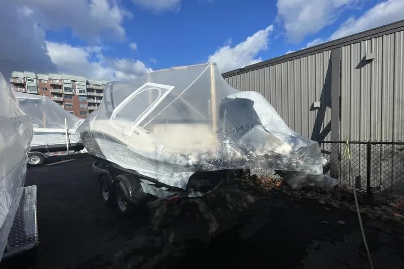 Slide: The Image of 2024 Sea Ray 230 Sportster Bow Rider covered in protective wrap, parked outdoors. - 5