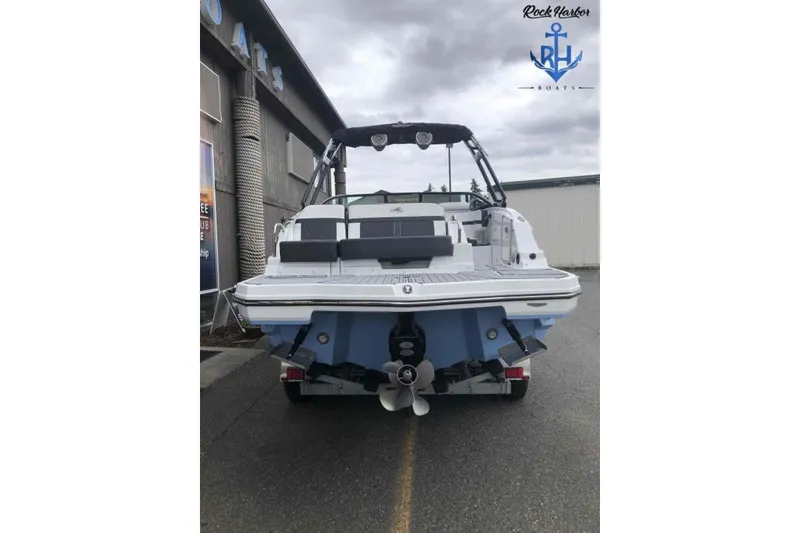 Slide: The Image of 2022 Monterey M6 boat, rear view, parked outdoors near a building. - 4