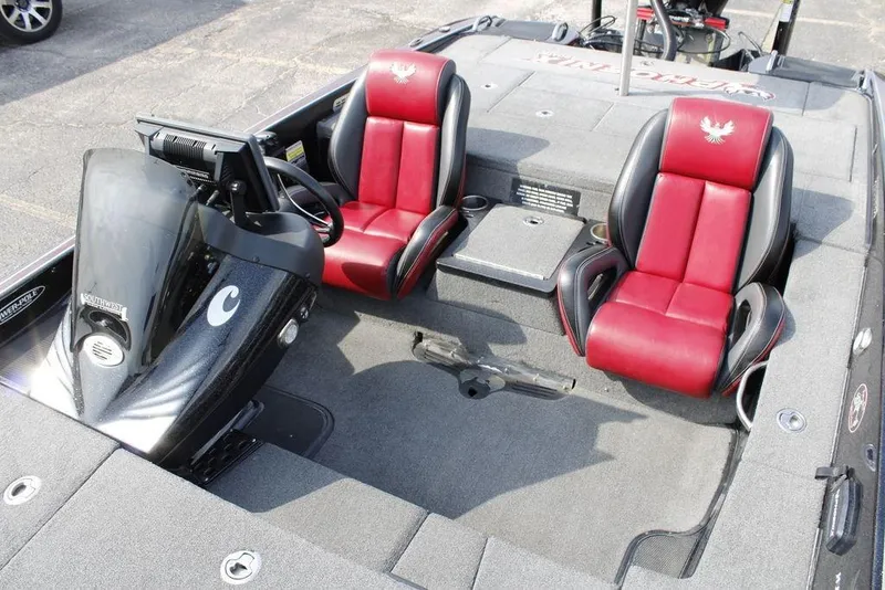 Slide: The Image of 2021 Phoenix 21 PHX boat interior with red and black seats, steering console, and carpeted flooring. - 17