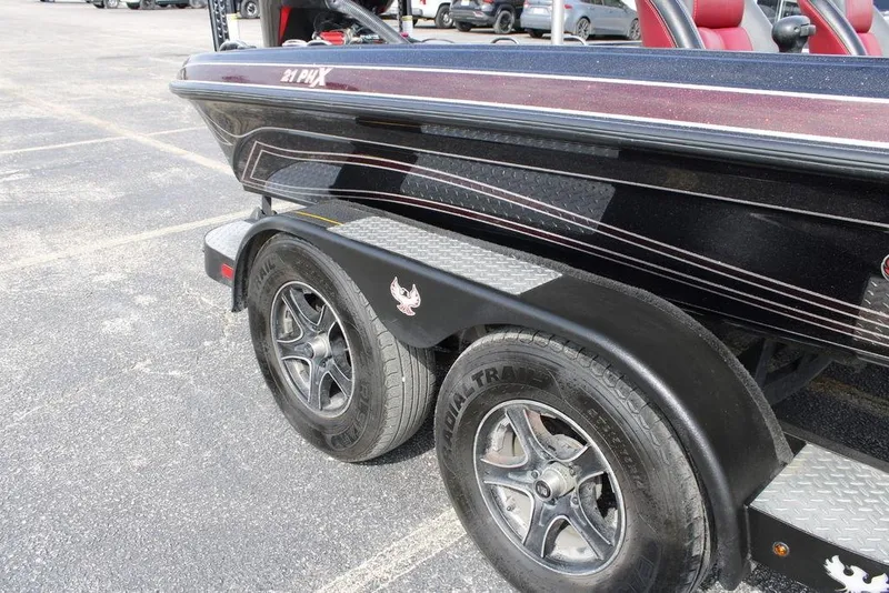 Slide: The Image of 2021 Phoenix 21 PHX boat trailer with dual wheels in a parking lot. - 2