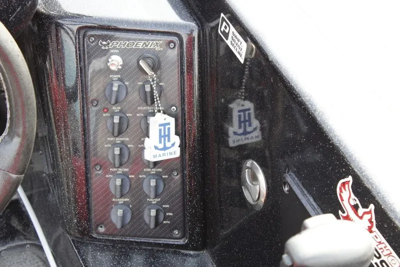 Slide: The Image of Control panel of a 2021 Phoenix 21 PHX boat with various switches and keychain. - 25