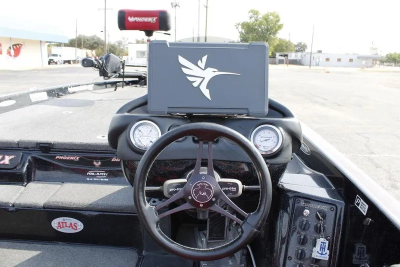 Slide: The Image of 2021 Phoenix 21 PHX boat dashboard with steering wheel and gauges. - 26