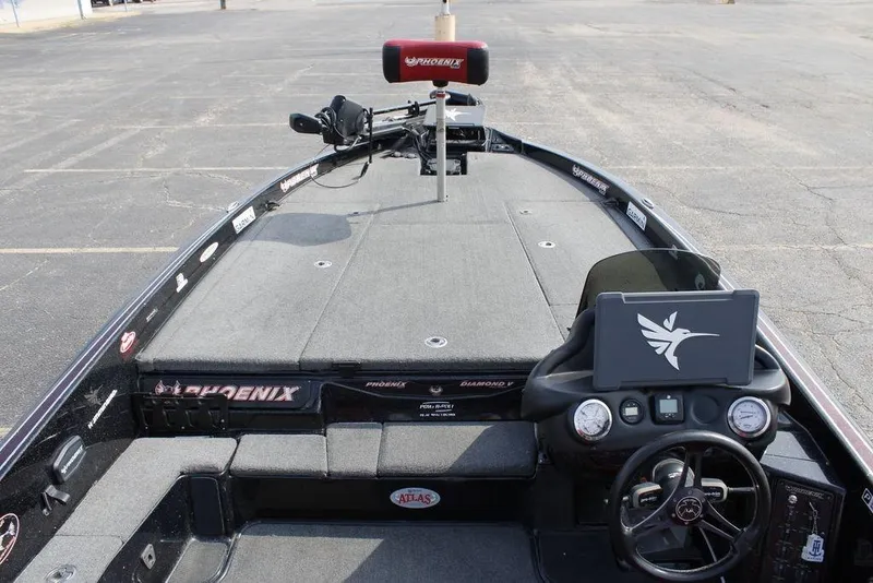Slide: The Image of 2021 Phoenix 21 PHX boat interior with steering wheel and dashboard in a parking lot. - 28