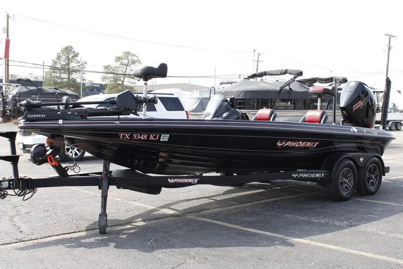 Slide: The Image of 2021 Phoenix 21 PHX boat on trailer, black with red accents, parked outdoors. - 37