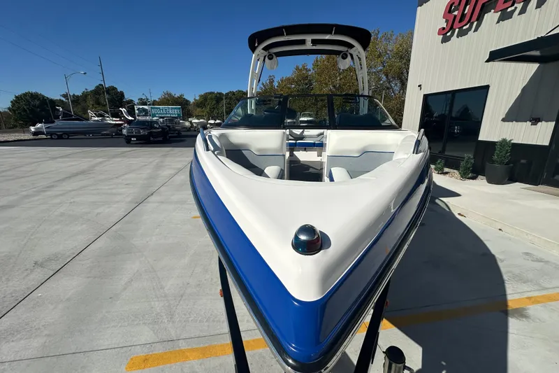 Slide: The Image of 2015 Moomba Mobius LSV boat with blue exterior and wakeboard tower under clear sky. - 10